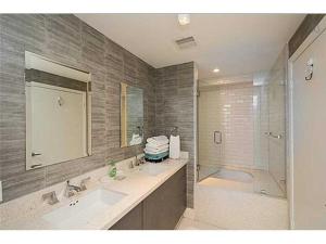a bathroom with two sinks and a shower and a tub at Heart of South Beach / Modern Apartment / Ocean Drive - Carlyle in Miami Beach +15 photos