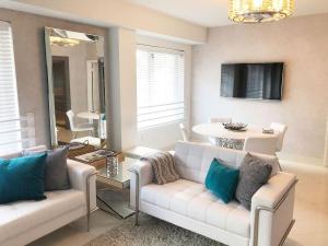 a living room with a white couch and a mirror at Heart of South Beach / Modern Apartment / Ocean Drive - Carlyle in Miami Beach