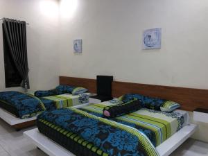 a room with three beds in a room at Rumah Singgah BRM in Bromo