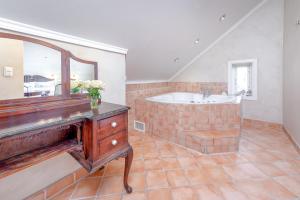 y baño con bañera, lavabo y espejo. en GamlaVaerket Hotel en Sandnes