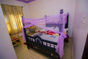 um quarto com uma cama de dossel em Nice Guest House em Jinja