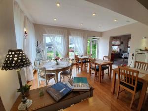 a dining room and living room with a table and chairs at AmberSeason Hotel in Zelenogradsk