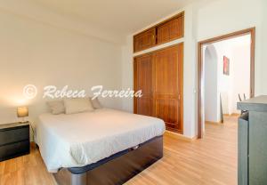 Schlafzimmer mit einem Bett und einem Holzschrank in der Unterkunft Villas2go2 T1 Miramar in Carvoeiro