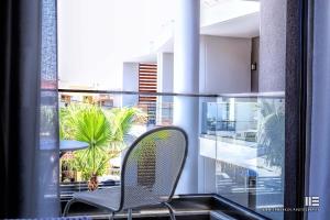 a chair sitting on a balcony with a view of a building at Senso Suites in Nea Peramos