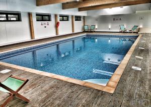 una gran piscina en un edificio con suelo de madera en The Bay Colwell, en Freshwater