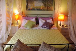 Un dormitorio con una cama con almohadas. en A Casa Olimpia B&B, en Giarre