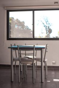 mesa y sillas en una habitación con ventana en Aqua Terra en Federación