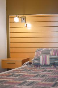 a bedroom with a bed and a wooden headboard at Aqua Terra in Federación