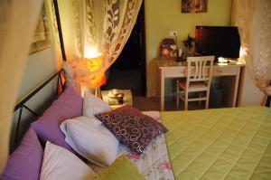 una camera da letto con un letto con cuscini di A Casa Olimpia Giarre tra Taormina, Etna e Catania a Giarre Altre 4 foto