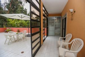 une terrasse avec une table, des chaises et un parasol dans l'établissement Like-home Bright Benfica Apt, à Lisbonne