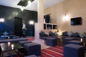un salon avec des canapés bleus et une télévision dans l'établissement Dar Chamaa, à Ouarzazate