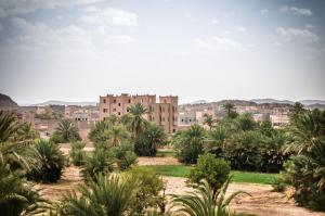 uma vista para uma cidade com palmeiras e um edifício em Dar Chamaa em Ouarzazate