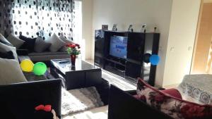 a living room with a large television and a couch at F3 Casabay beach sidi rahal vue sur piscine in Sidi Rahal