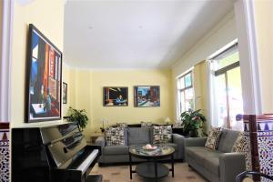 sala de estar con sofá y piano en Hotel Cabello, en Torremolinos