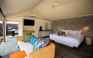 a living room with a bed and two couches at Origin Uluwatu in Uluwatu