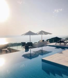 Villa Salina Luxury Pool Villa في Kechria: المسبح مع الكراسي والمظلات والماء