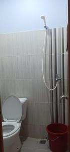 La salle de bains est pourvue de toilettes et d'une douche avec un tuyau. dans l'établissement Rumah Singgah BRM, à Bromo