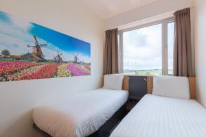 a room with two beds and a painting of a windmill at Maxhotel Amsterdam Airport Schiphol in Hoofddorp