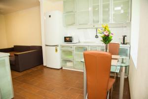 a kitchen with a table and a white refrigerator at 2 Rooms Luxury Apartment on Divnogorskaya 13 Street in Zaporozhye