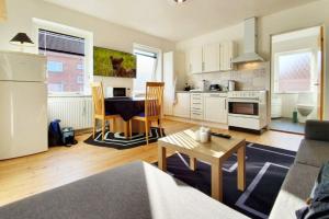 a kitchen and living room with a couch and a table at Struer Town Apartment in Struer