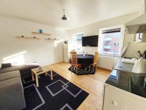 a small living room with a table and a kitchen at Struer Town Apartment in Struer