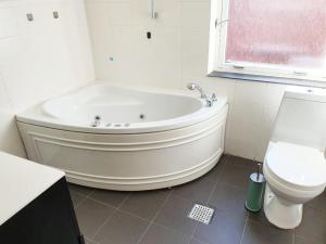a white bathroom with a tub and a toilet at Struer Town Apartment in Struer +10 photos