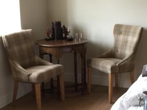 une petite table avec deux chaises et une table avec une table dans l'établissement Hill Farm Bed and Breakfast, à Little Massingham