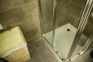 a shower stall with a glass door and a shower at Caparica Sea View Apt by be@home in Costa da Caparica +33 photos