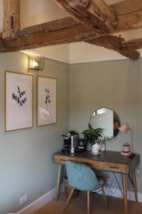 a desk with a mirror and a blue chair at The Nags Head Hotel in Great Missenden