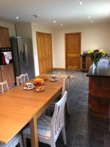 a kitchen with a large wooden table and chairs at Glendona Cottage in Crumlin