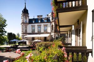 un grand bâtiment blanc avec une tour d'horloge dans l'établissement Hôtel Château de l'ile, à Ostwald