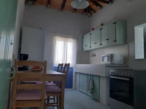 a kitchen with a table and chairs and a microwave at Villa Avli in Kardamili