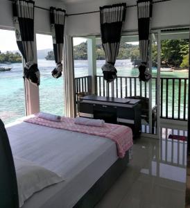 a bedroom with a bed with a view of the water at Mr. Bean Resort in Sabong