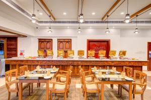 a restaurant with wooden tables and chairs and a bar at Sterling Guruvayur in Guruvāyūr