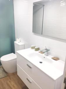 een witte badkamer met een toilet en een wastafel bij OceanFront Flat I by Canary365 in Las Palmas de Gran Canaria