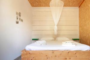 a bedroom with a bed with two towels on it at Himara Hostel in Himare
