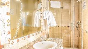 
a bathroom with a tub, sink and mirror at Hotel Albero in Granada
