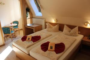 1 dormitorio con 2 camas con corbatas de lazo en Pension Zur Grünen Eiche en Kaulsdorf