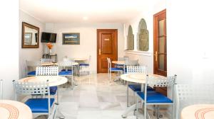 un comedor con mesas y sillas azules en Hotel Albero en Granada