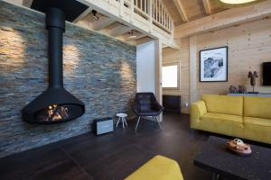 a living room with a fireplace and a yellow couch at Superbe chalet-11 personnes-Chamonix(Les Bossons) in Chamonix-Mont-Blanc
