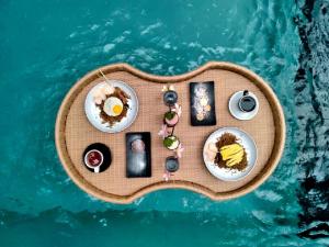 uma mesa em miniatura com comida em cima da água em Annupuri Villas Bali em Canggu