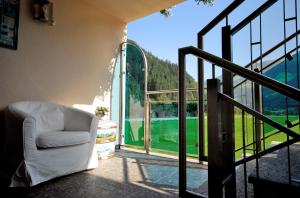 a white chair sitting on a balcony looking out at a golf course at Apartment Sonnenau in Zell am Ziller