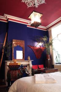 a bedroom with blue walls and a bed and a mirror at Atlas B&B in Ghent