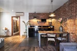 a kitchen with a brick wall and a table and chairs at Brummell Apartments Eixample Izquierda/Valeris in Barcelona