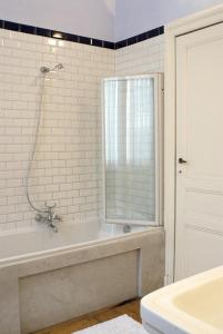 a white bathroom with a tub and a window at Atlas B&B in Ghent