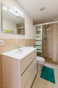 a bathroom with a sink and a toilet and a mirror at Apartamentos Mallorca SL in Cala Millor