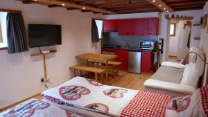 Habitación con cocina con armarios rojos y mesa. en Studio Clausen Kurt, en Ernen