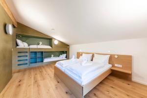 a bedroom with a large white bed and shelves at Kuglerhof Appartements in Seeboden