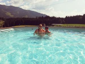 a woman and a child in a swimming pool at Oberstockinghof in Saalfelden am Steinernen Meer