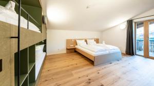 sypialnia z łóżkiem i dużym oknem w obiekcie Kuglerhof Appartements w mieście Seeboden